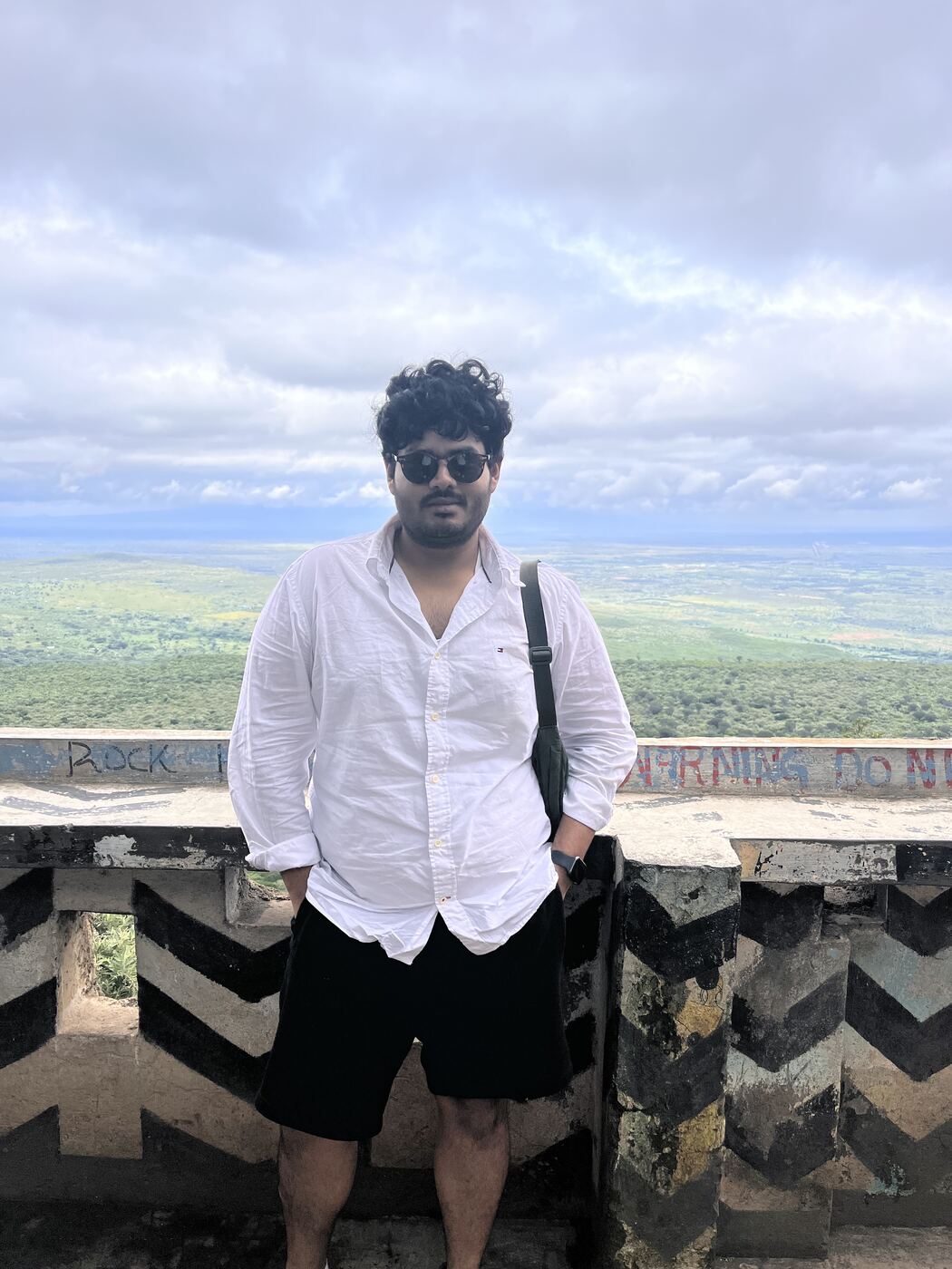Anmol at a hilltop overlook above green plains