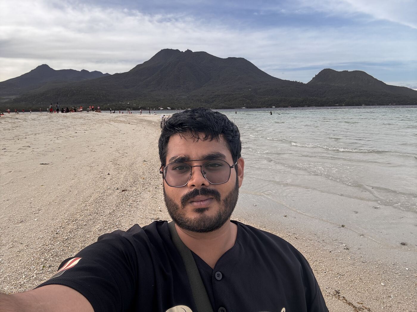 Selfie on a beach with volcanic peaks behind